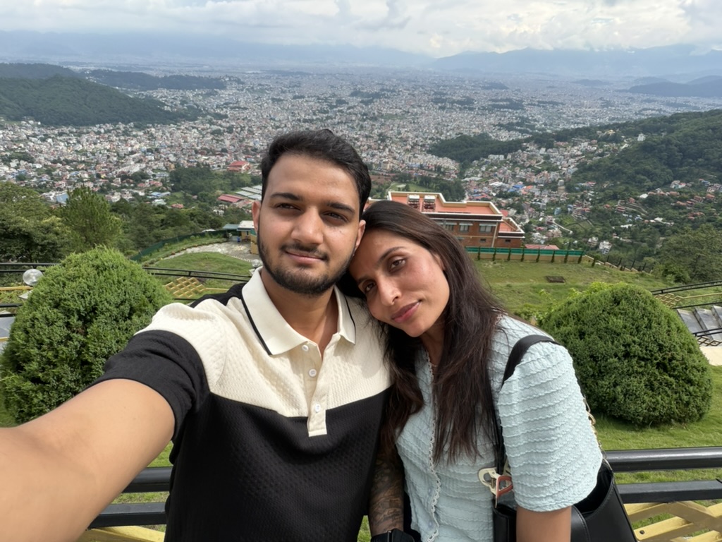 The two of us cheek to cheek on a hilltop with the whole Kathmandu valley spread out behind us